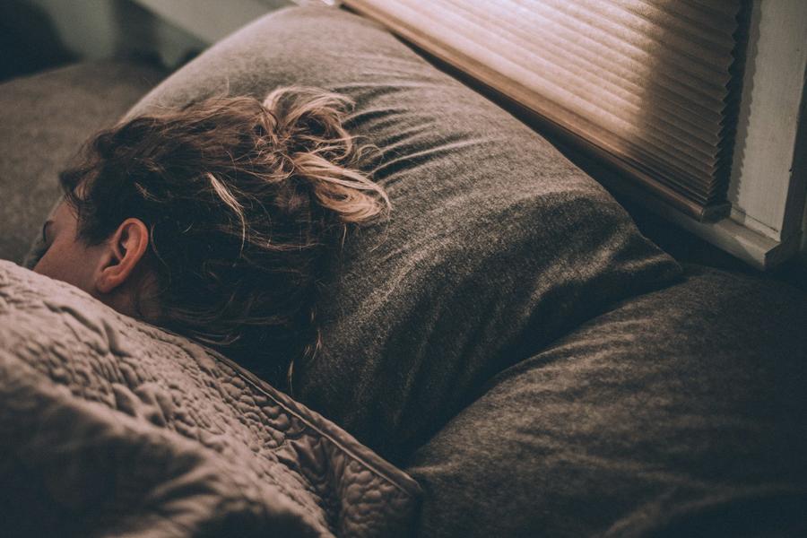 Mujer durmiendo en la cama bajo las mantas