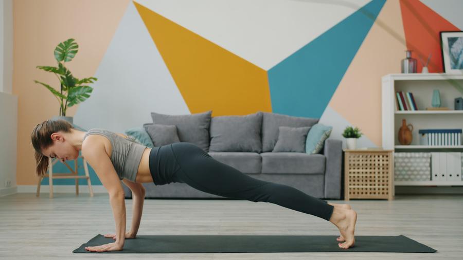 Mujer haciendo una plancha sobre un mat de yoga