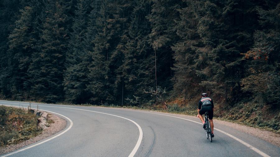 Ciclista en una bicicleta de ruta por un camino en el bosque