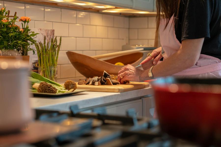 Mujer en la cocina cortando verduras sobre una tabla