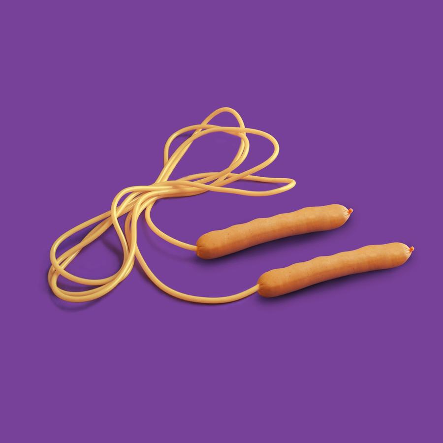 Una soga de saltar amarilla con mangos de madera sobre un fondo violeta liso