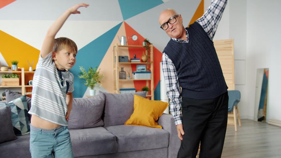 Abuelo y nieto haciendo ejercicio juntos en interiores