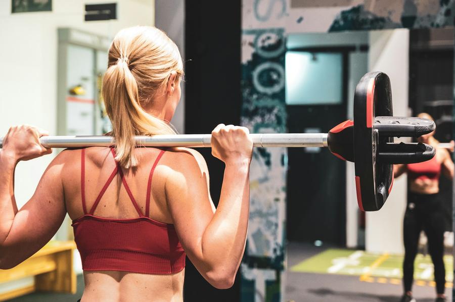 Mujer levantando una barra en el gimnasio