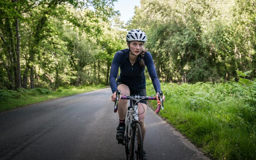 Mujer andando en bicicleta por un camino rural