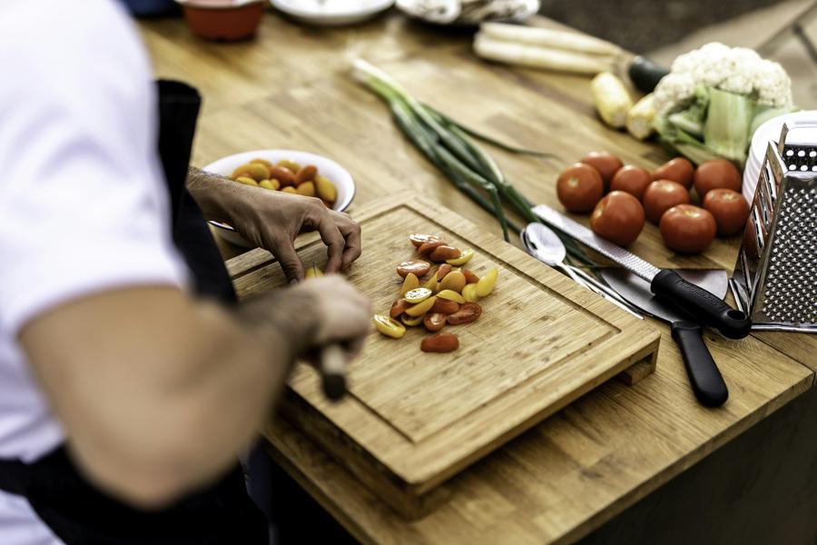 Persona cortando verduras sobre una tabla