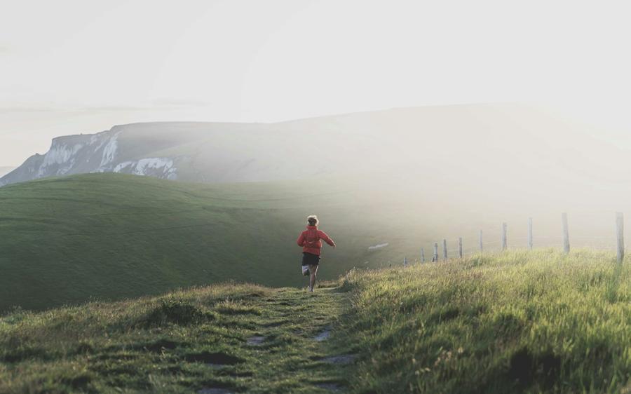 Hombre corriendo por un sendero de montana